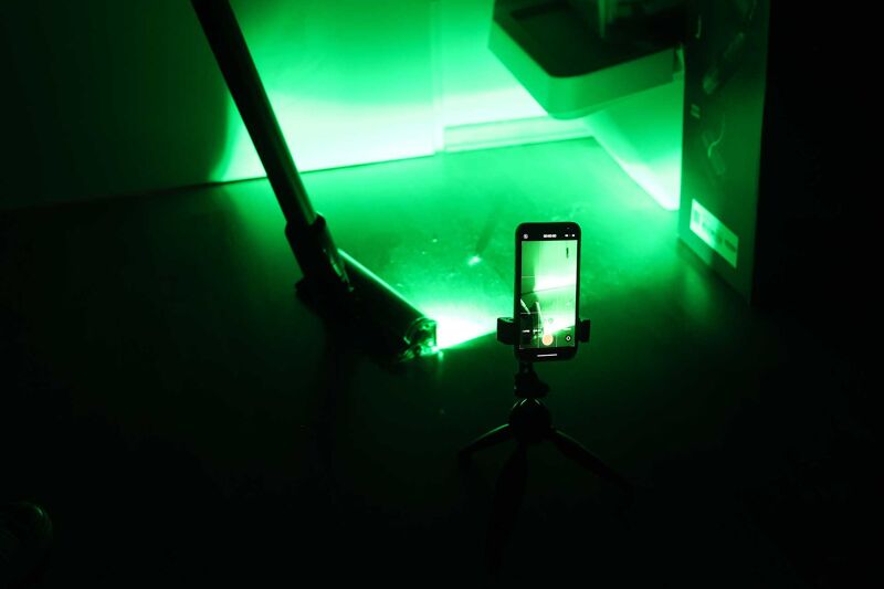 Dyson Gen5detect’s fluffy optic cleaner head laser in the dark.